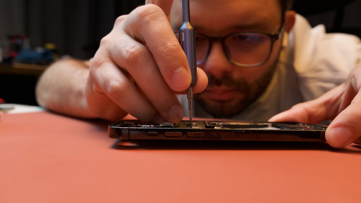 Luis Araujo reparando un iPhone con herramientas de precisión